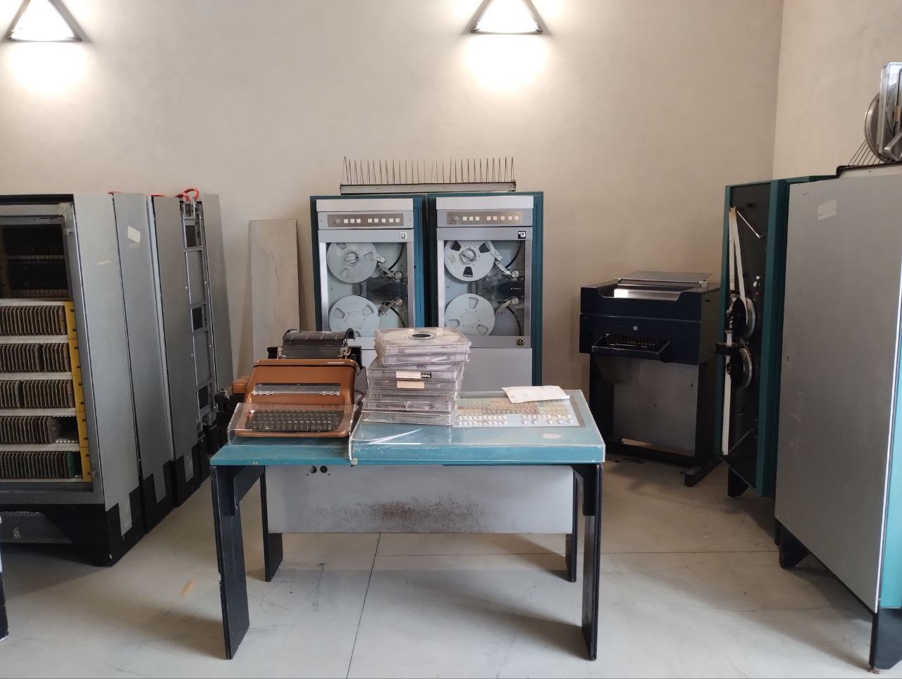 Il calcolatore Elea 6001 è costituito dall'unità di elaborazione centrale con armadi che si aprono a ventaglio, i lettori di nastro perforato e nastro magnetico, e la console colorata.