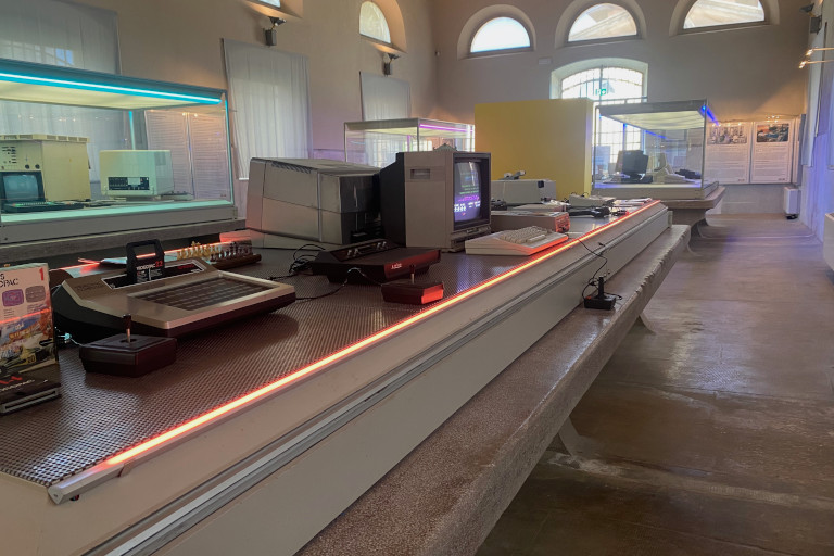 La vitrine des jeux vidéo de l'exposition « non solo calcolo », qui contient entre autres un Commodore 64 et un Atari 2600.